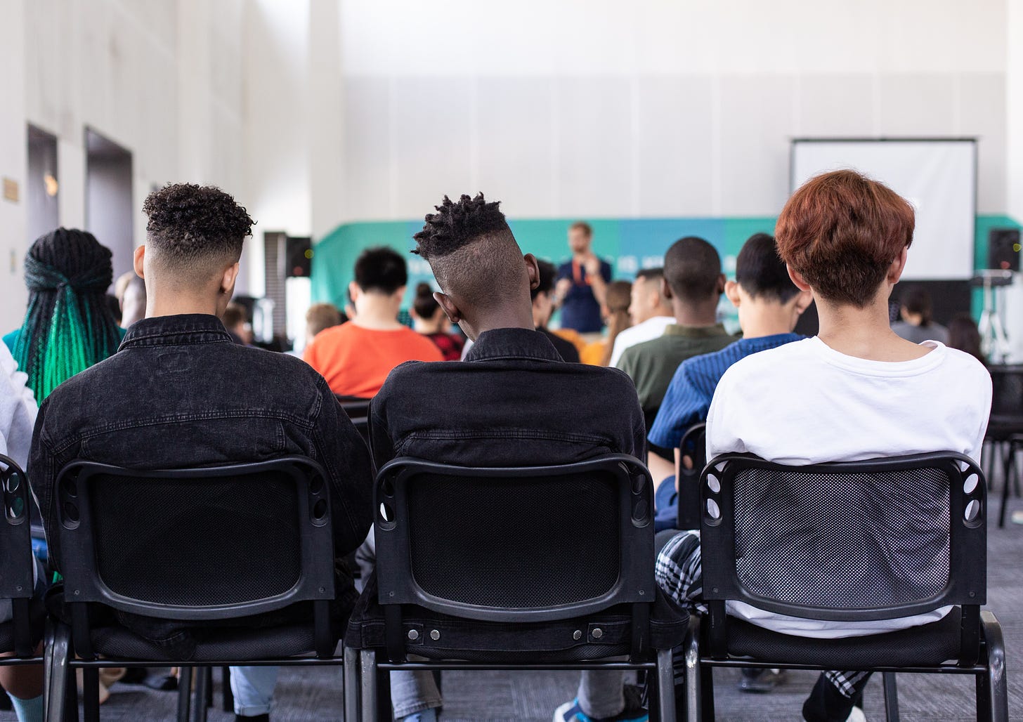 School class with three boys sitting in the back row.