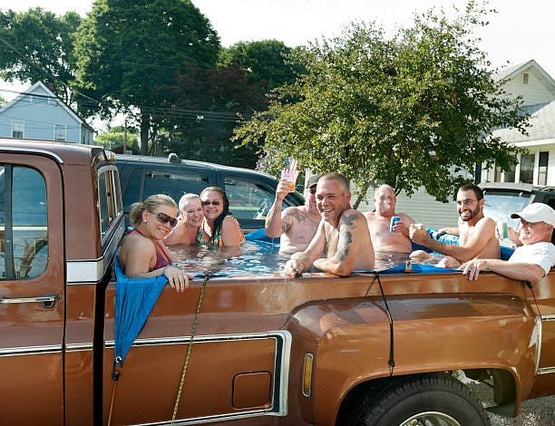 Redneck hot tub, 8 people partying in back of pick-up truck Eight people having fun in the back of a pick-up truck filled with water. small town fun stock pictures, royalty-free photos & images