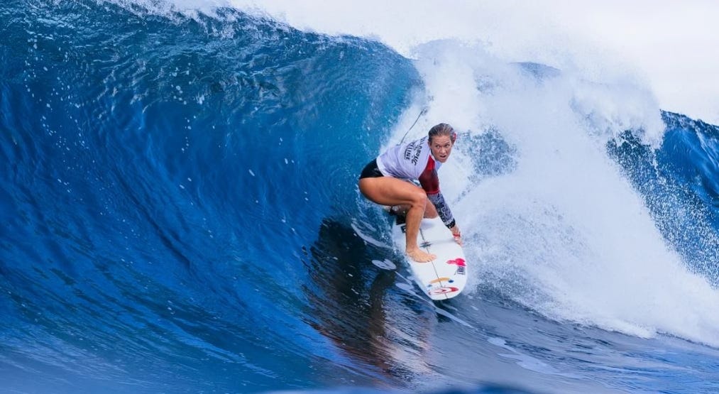 Bethany Hamilton powerfully maneuvers on her surfboard, showcasing her skill and determination as she rides the waves.