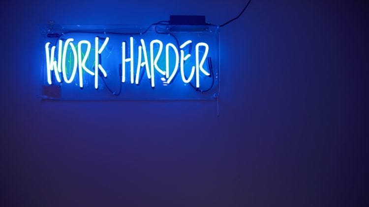Neon sign that reads "Work harder" -- an inspiration for hustle culture