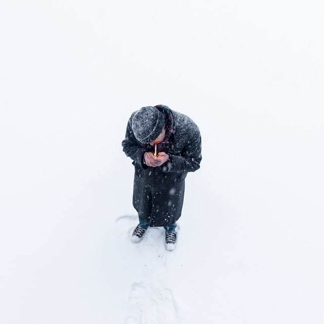 Lighting a cigarette on snowy day