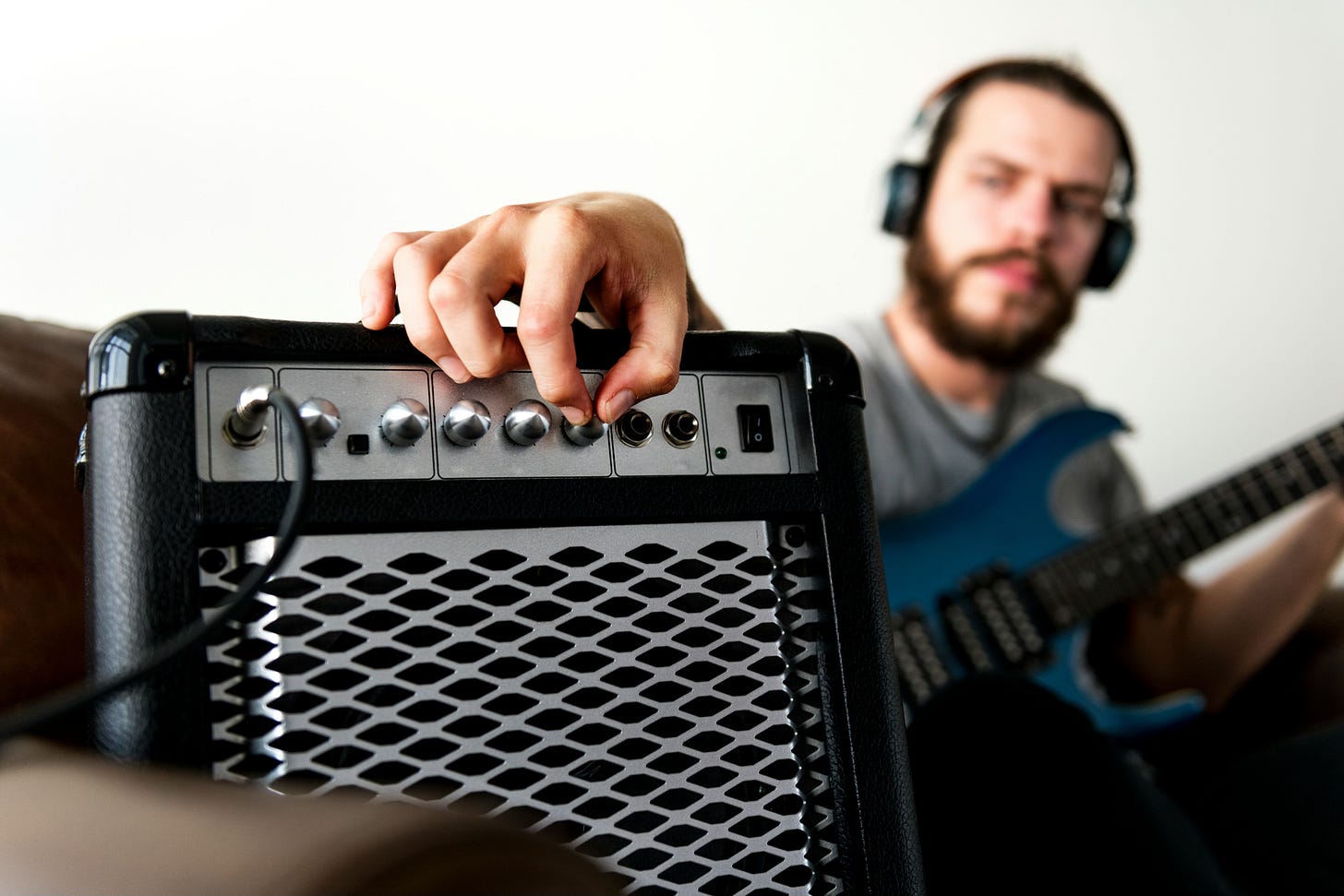 Guy adjusting a guitar amplifier