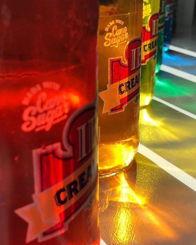 close-up of light shining through bottles of colored water, forming a rainbow