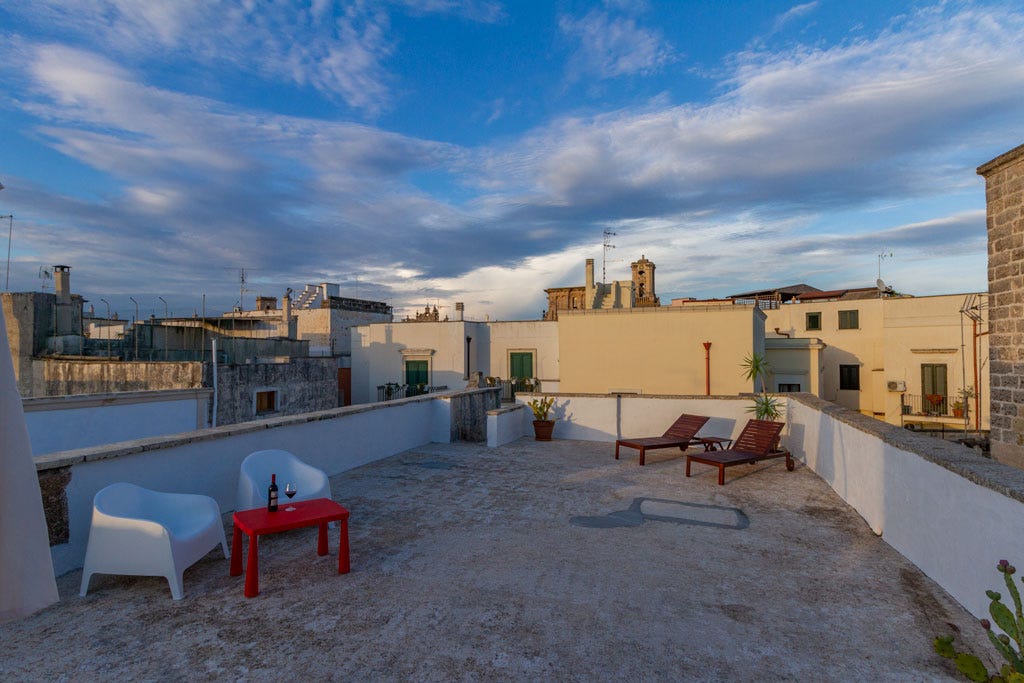 roof terrace in Nardò charis with a table and wine, out look over the city skyline