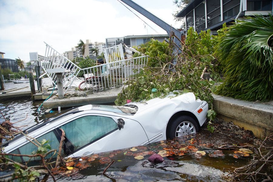 Vehicles thrown into a canal by Hurricane Ian are seen on Thursday, Sept. 29, 2022 in Bonita Beach.