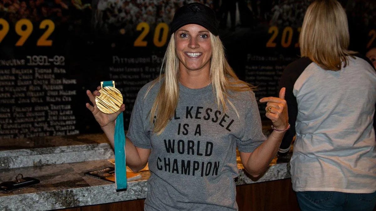 Amanda Kessel posing with a gold medal.