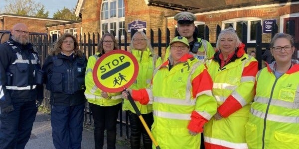 Police officer and crossing patrol staff outside the school