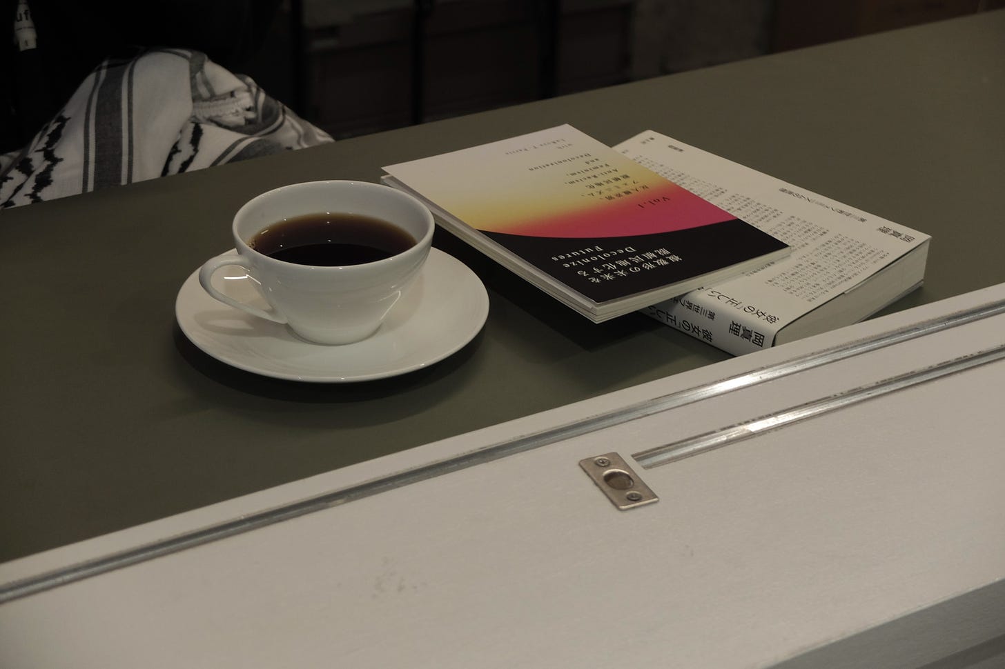 店内カウンターの写真。コーヒーカップの横に本が2冊積まれている。