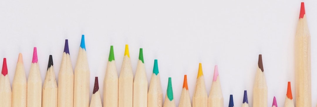 colored pencil lined up on top of white surface colored pencil lined up on top of white surface
