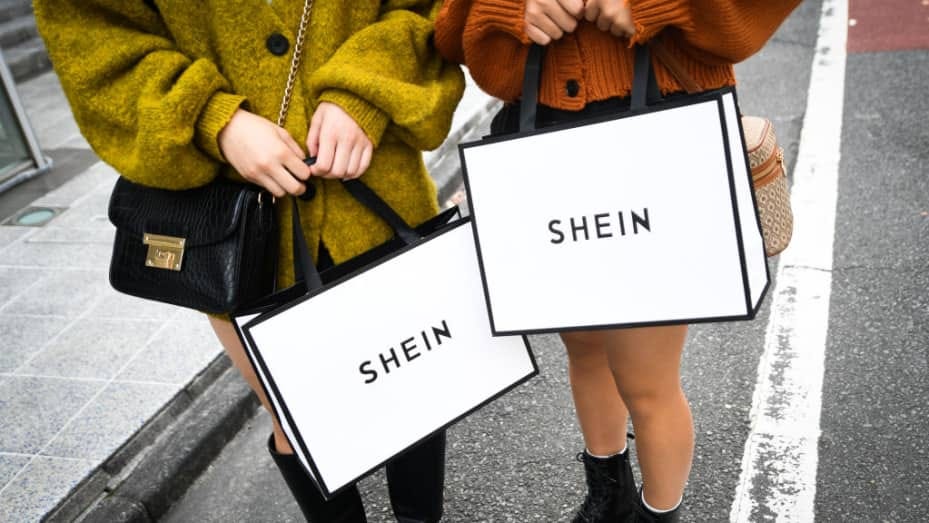 Customers hold shopping bags outside the Shein Tokyo showroom in Tokyo on Nov. 13, 2022. Reuters reports the fast fashion retailer is targeting a U.S. IPO in the second half of 2023.