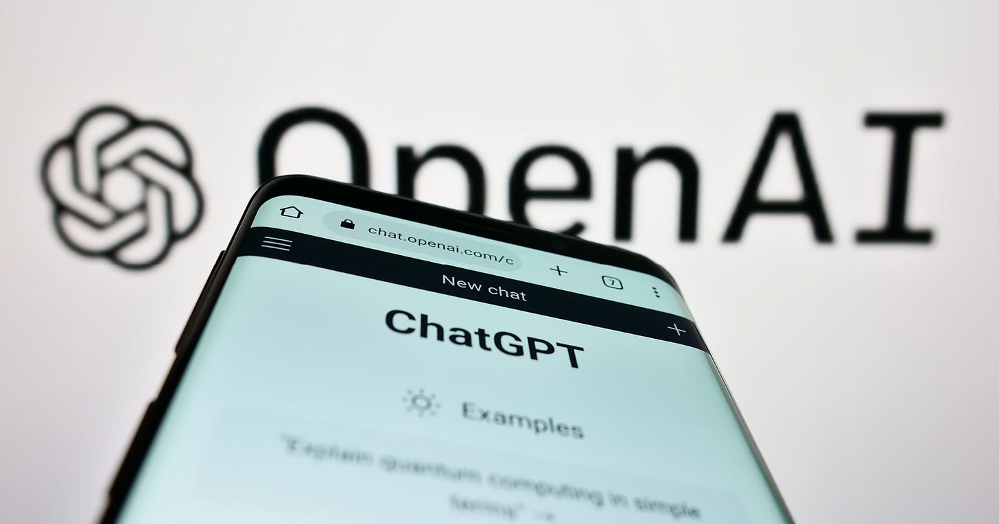 Imagem com um smartphone, na tela está aberto o website com o ChatGPT, ao fundo há o logotipo da empresa OpenAI