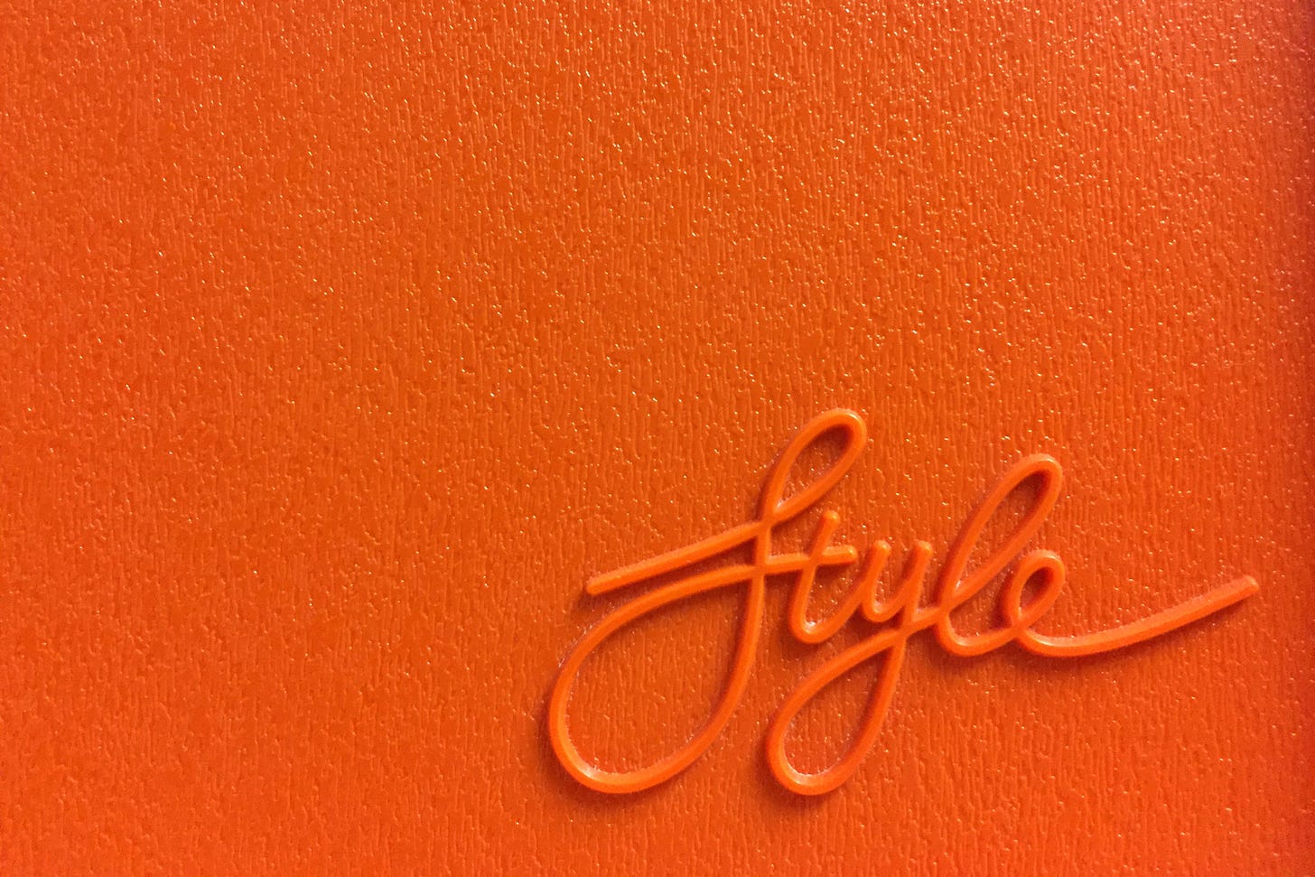 raised orange cursive text that reads 'style' on an orange, textured background