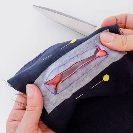 Cutting through the different fabric pieces that are on top of each other