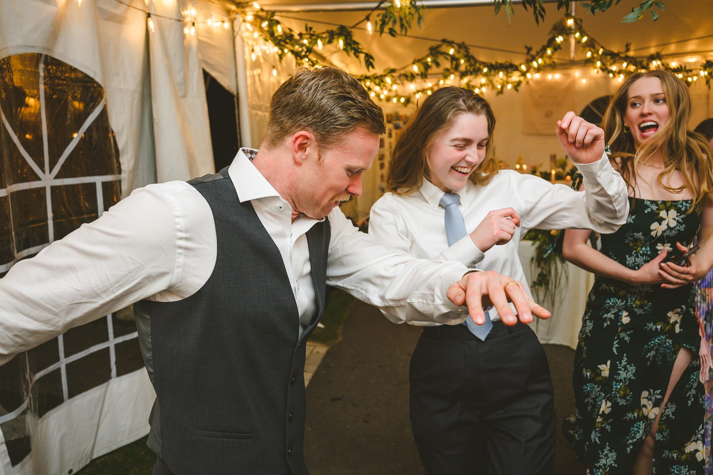 A groom and some guests dancing