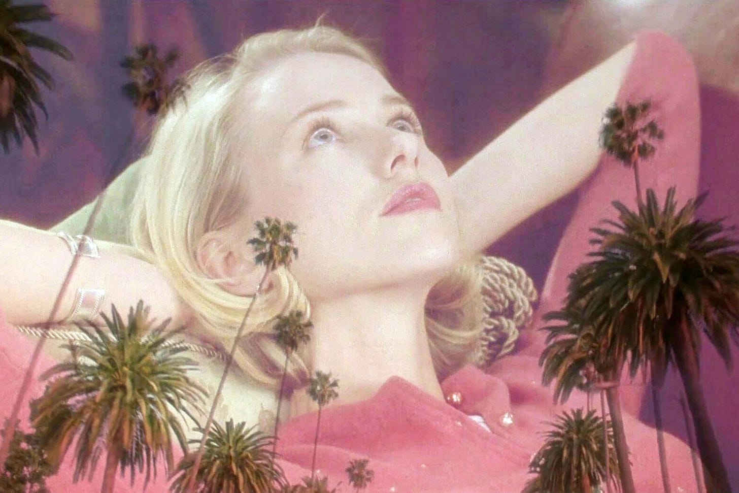 Naomi Watts reclines in a pink cardigan, her body superimposed over a Los Angeles sunset, in "Mulholland Drive" (2001)