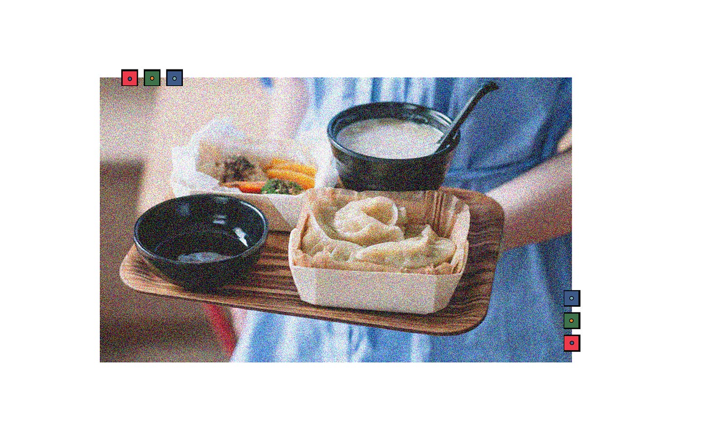 A person holds a tray with a lunch set including momos