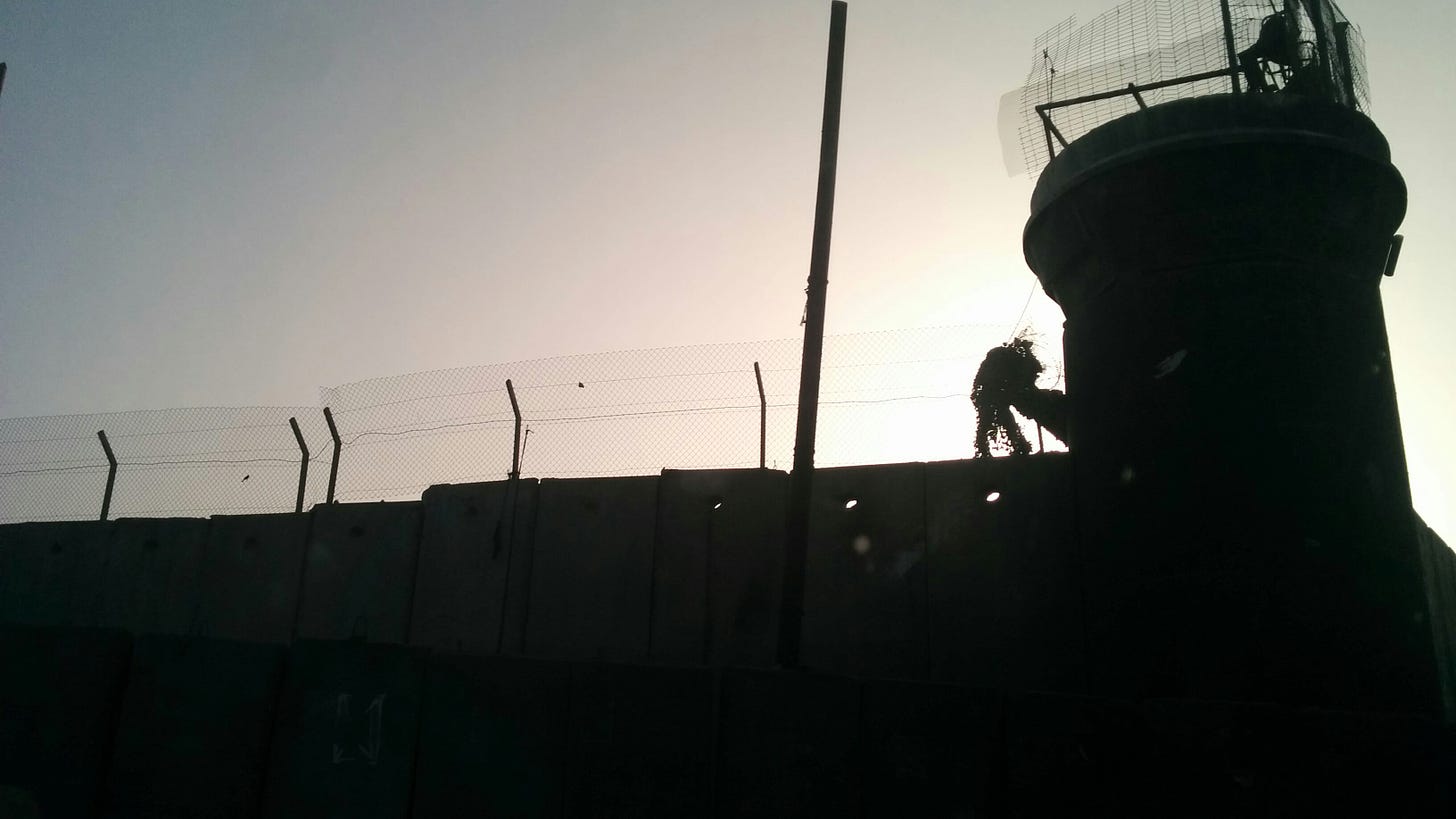 Silhouette of a guard tower and concrete wall