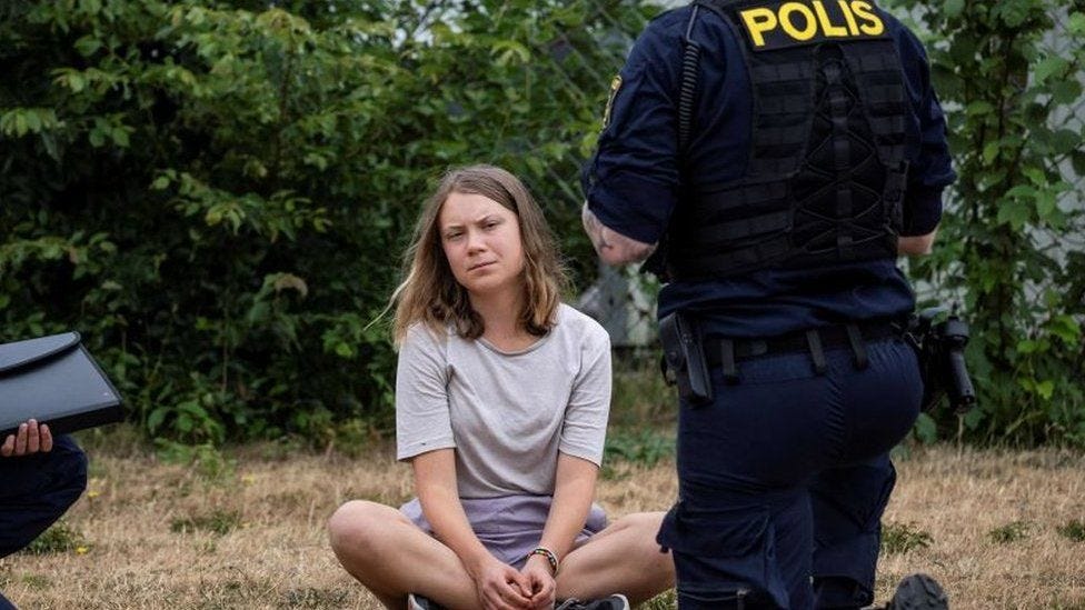 Police officers speak to Swedish climate activist Greta Thunberg as they are about to remove other climate activists from the organization 'Ta Tillbaka Framtiden'