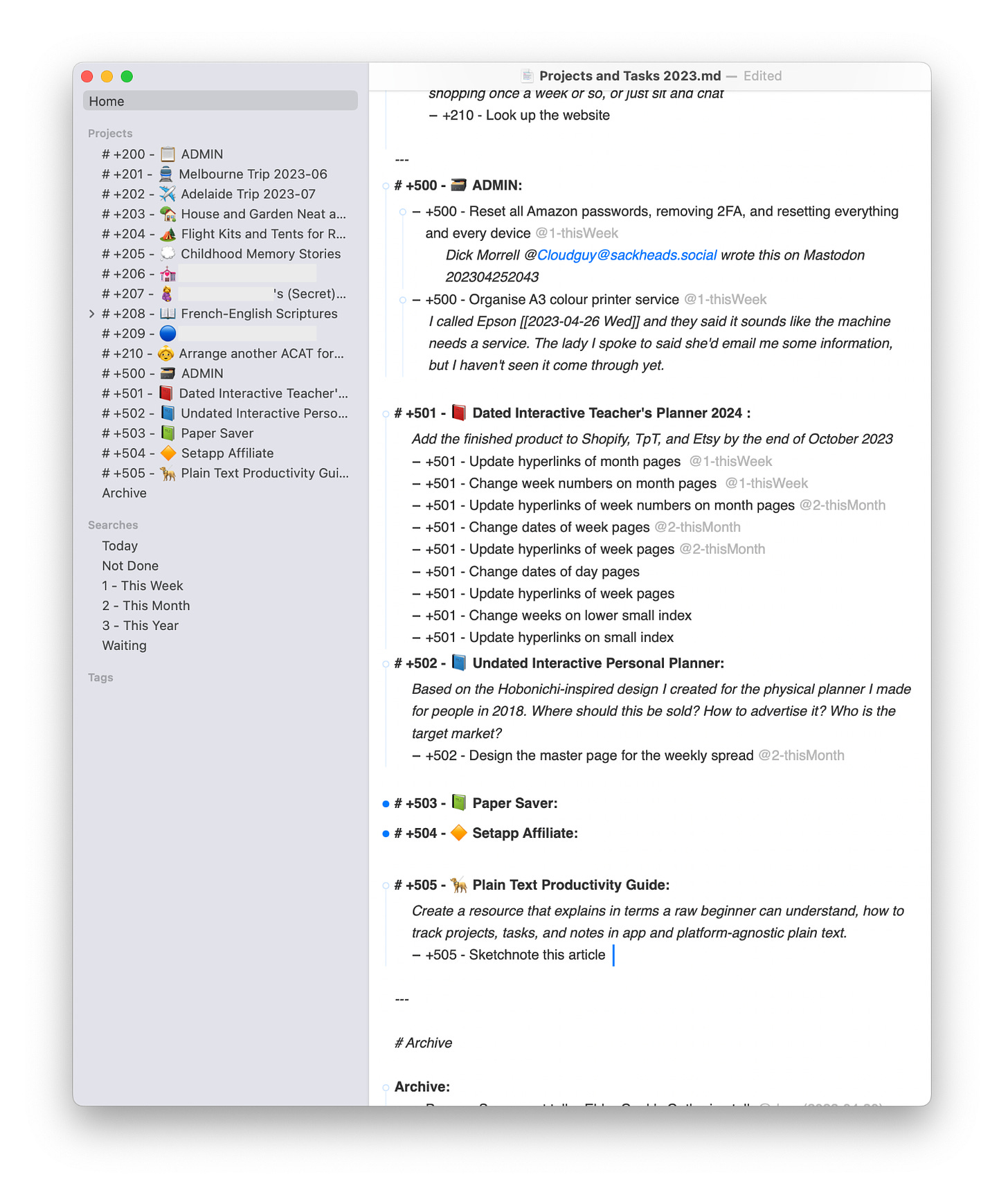 TaskPaper app window with a Mac-esque shadow behind it. There’s a narrow column on the left with a grey background, listing all projects and saved searches. On the right is a wider column with a white background showing a list of projects and tasks following the TaskPaper syntax. Projects are preceded by a number, and include an emoji related to the topic.