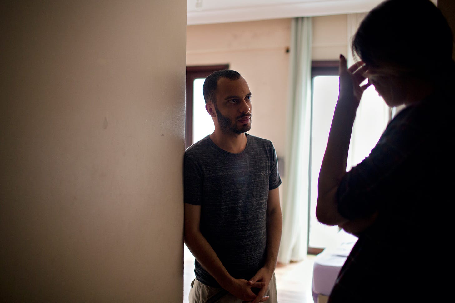 Aws, left, a volunteer at Aman LGBT Shelter, speaks with a trans woman from Iran who lives at the shelter.