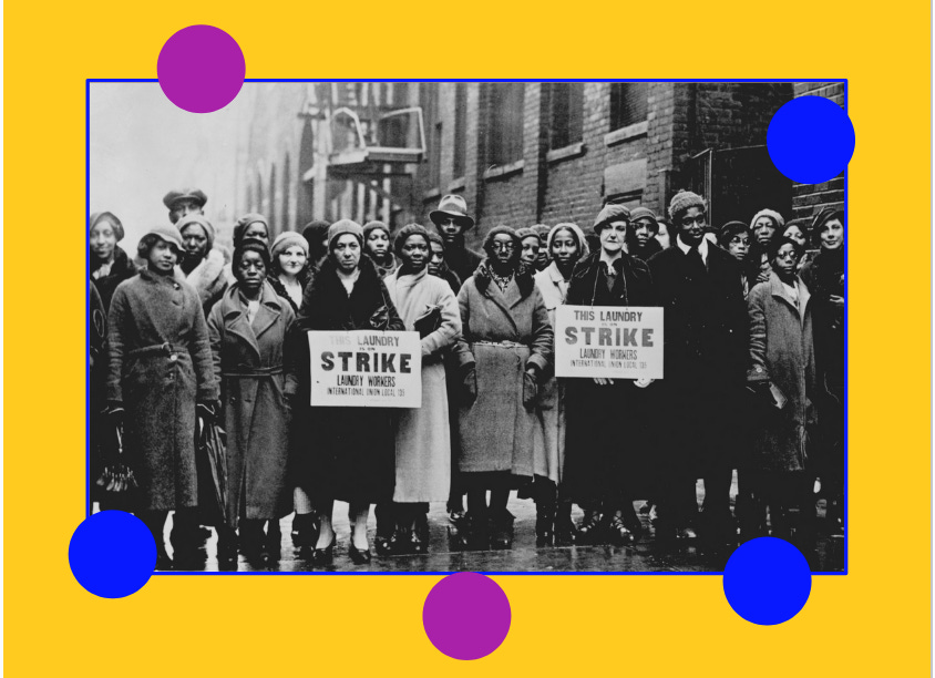 A black and white photograph of women (varying races, ages, stature – all wearing coast) lined up on a wet street. Two groups in the center are holding signs that read “THIS LAUNDRY IS ON STRIKE”)