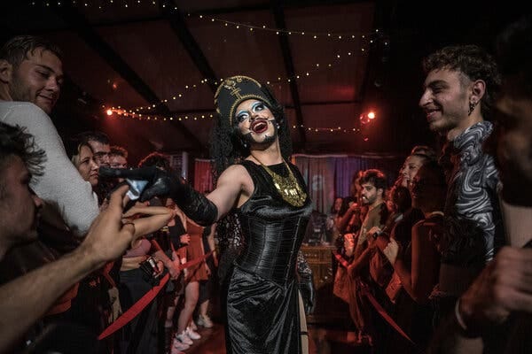 A drag performer surrounded by a group of people.