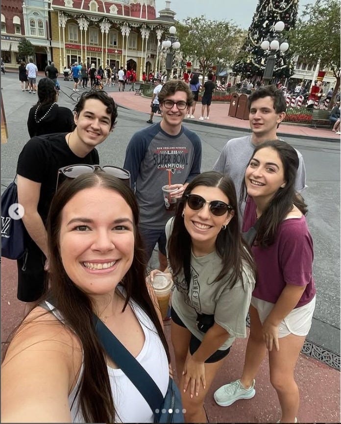 Gang of six 20-somethings posing for a selfie at the foot of Main Street at Disney World's Magic Kingdom