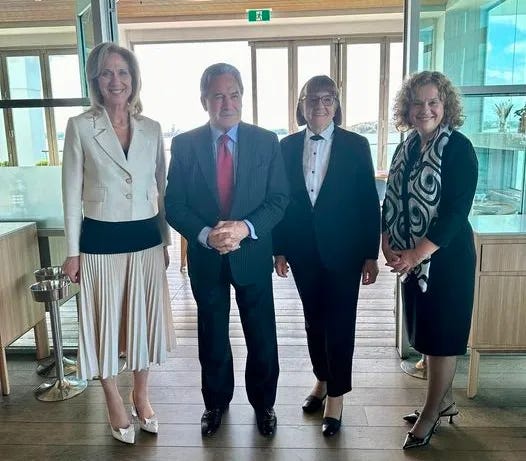 three women and a man all in formal clothes