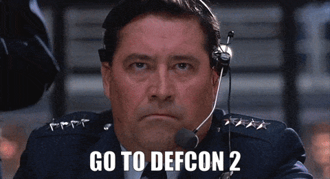 Animated GIF from WarGames. The General commands, "Go to DEFCON 2." The sign is shown flipping from a yellow 3 to a red 2, followed by a closeup of a red siren light spinning.
