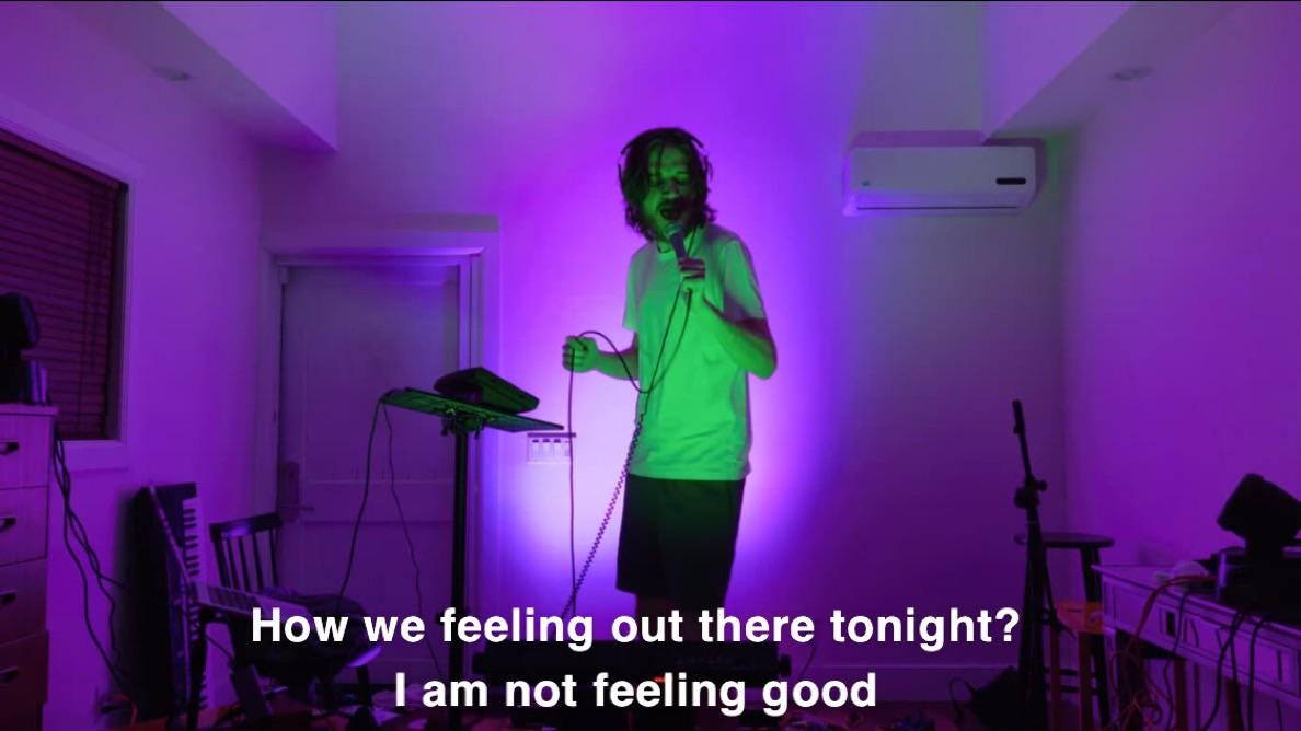 A screenshot from Bo Burnham's Netflix comedy special, Inside, that says, "how are we feeling tonight? I am not feeling good."