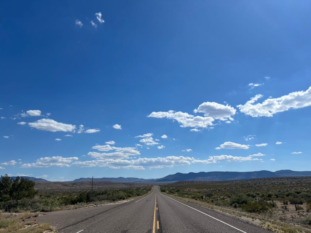 A road with mountains in the background

Description automatically generated