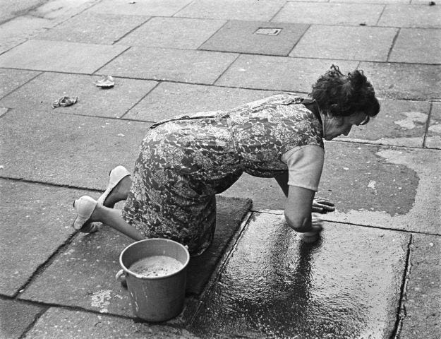 cleaning the pavement outside her home
