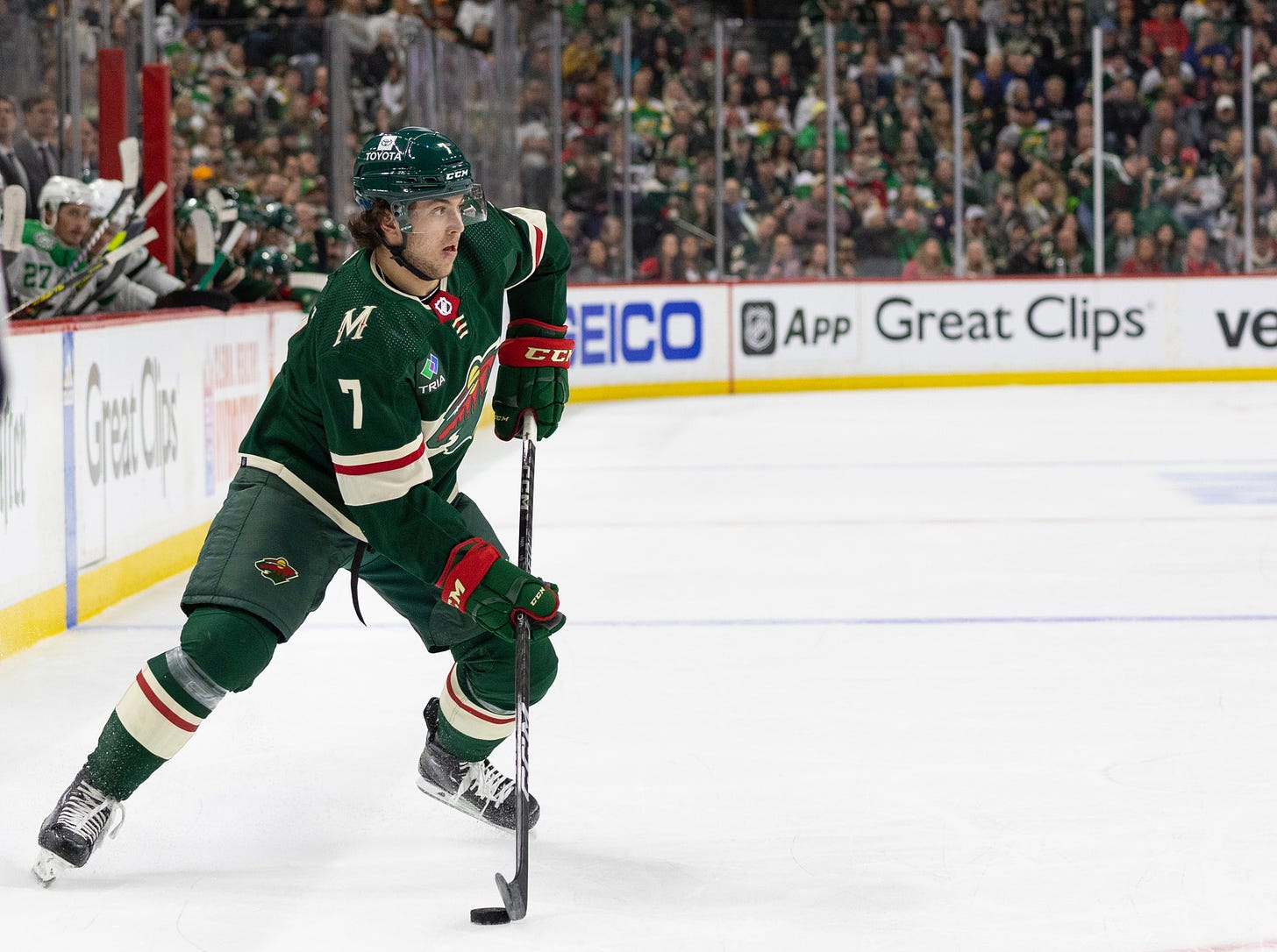 Faber scans the ice with the puck on his stick.