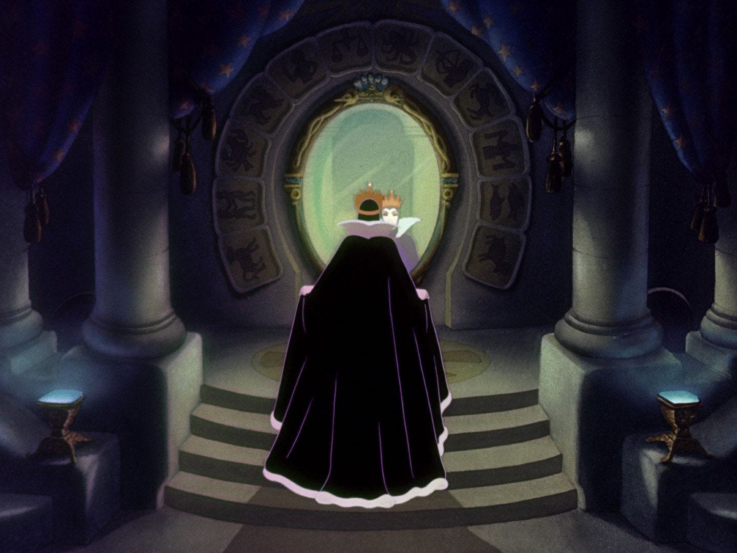 Scena del film animato Disney Biancaneve, in cui la regina, di spalle con indosso un mantello nero, si guarda allo specchio, circondato da segni zodiacali e due colonne