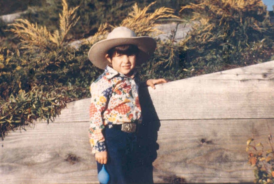 Karen as a child in cowboy outfit holding a water balloon.