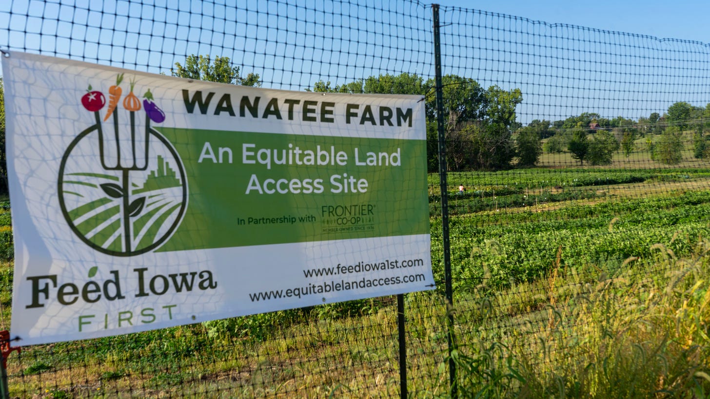A fenced in field with a sign on it with the words 'Wanatee Farm An Equitable Land Access Site'. 