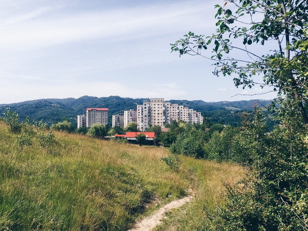 The neighborhood of Dallas in Vulcan, Romania. Ten story communist blocs as seen from a forest path