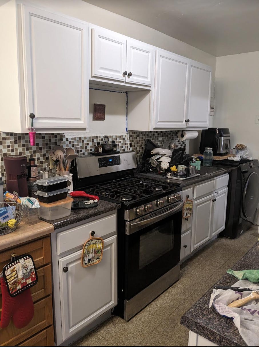 The same kitchen now shows the cabinets put back together and painted in white
