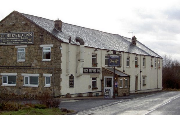 Picture from outside of the Twice Brewed Inn - a long stone-built building with a white front face.