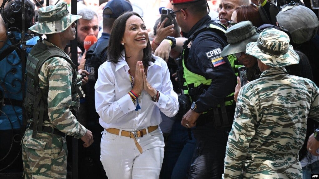 La dirigente de la oposición venezolana, María Corina Machado, saluda a electores, periodistas y personal de su centro de votación en Caracas, el 28 de julio de 2024.