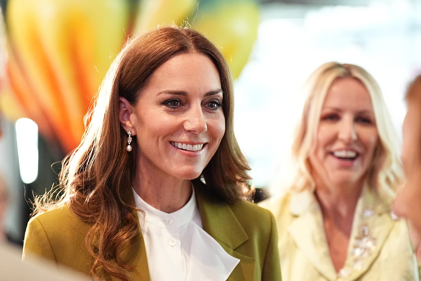 Princess Catherine smiling in a green Victoria Beckham suit