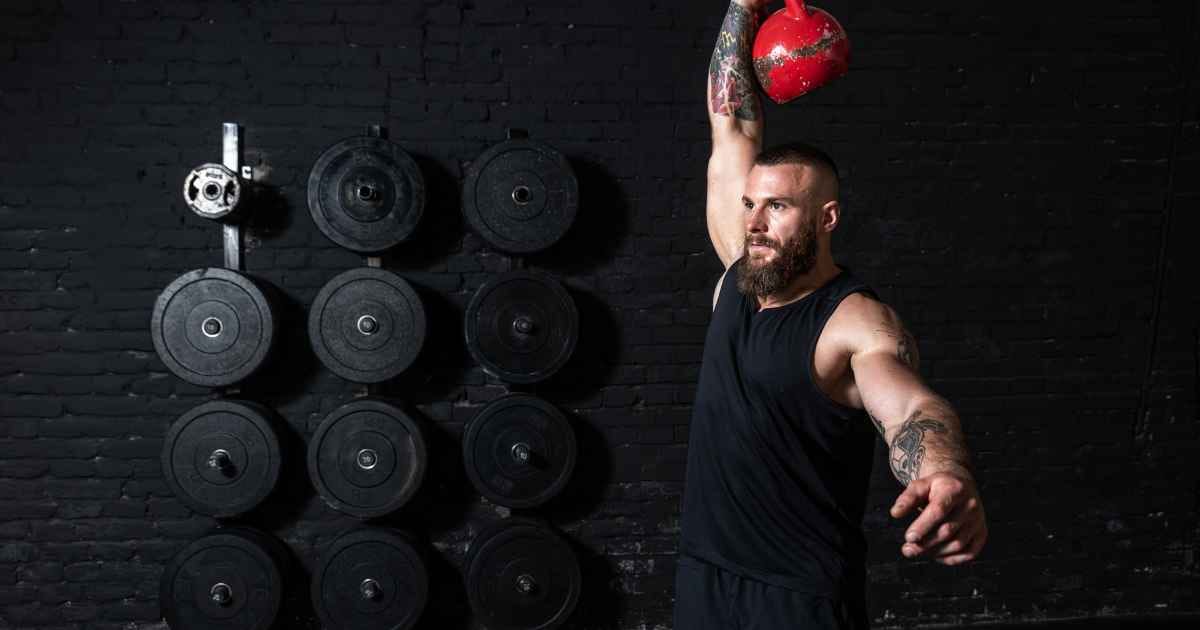 a man doing a kettlebell snatch workout in the gym
