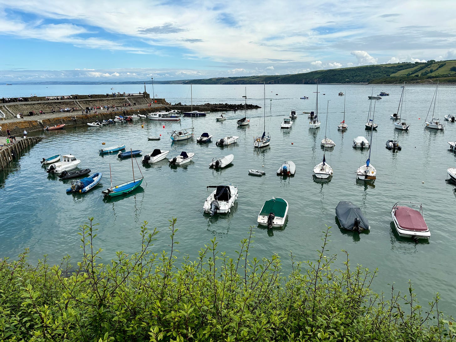 Over 30 small boats in a harbour. 