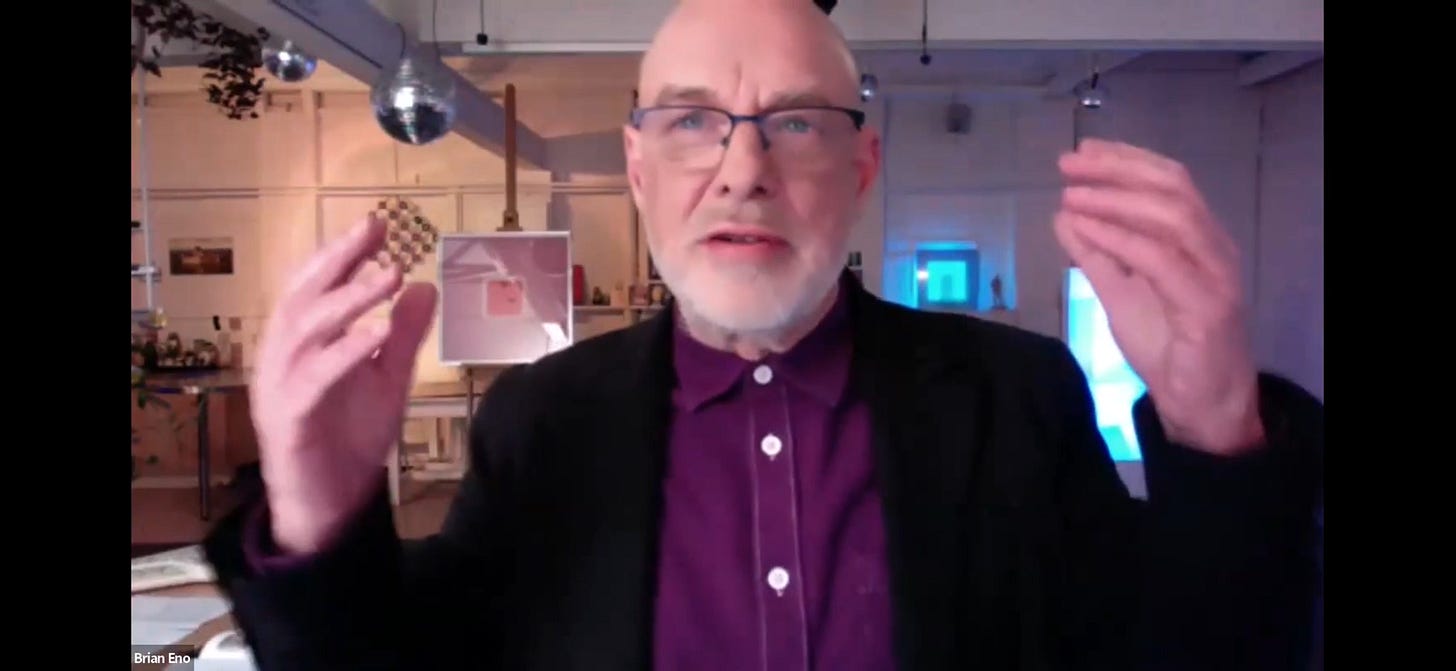 A video screenshot of Brian Eno talking, in his studio.
