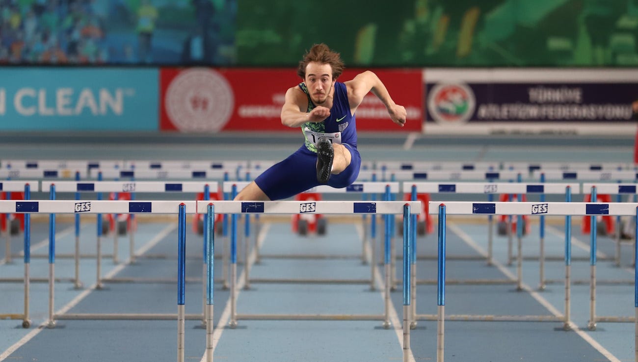 Hurdler in mid air over a jump