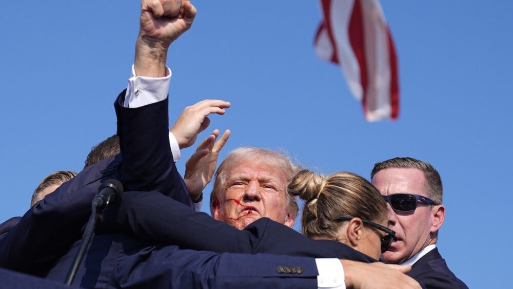 Trump raises his fist after being shot.