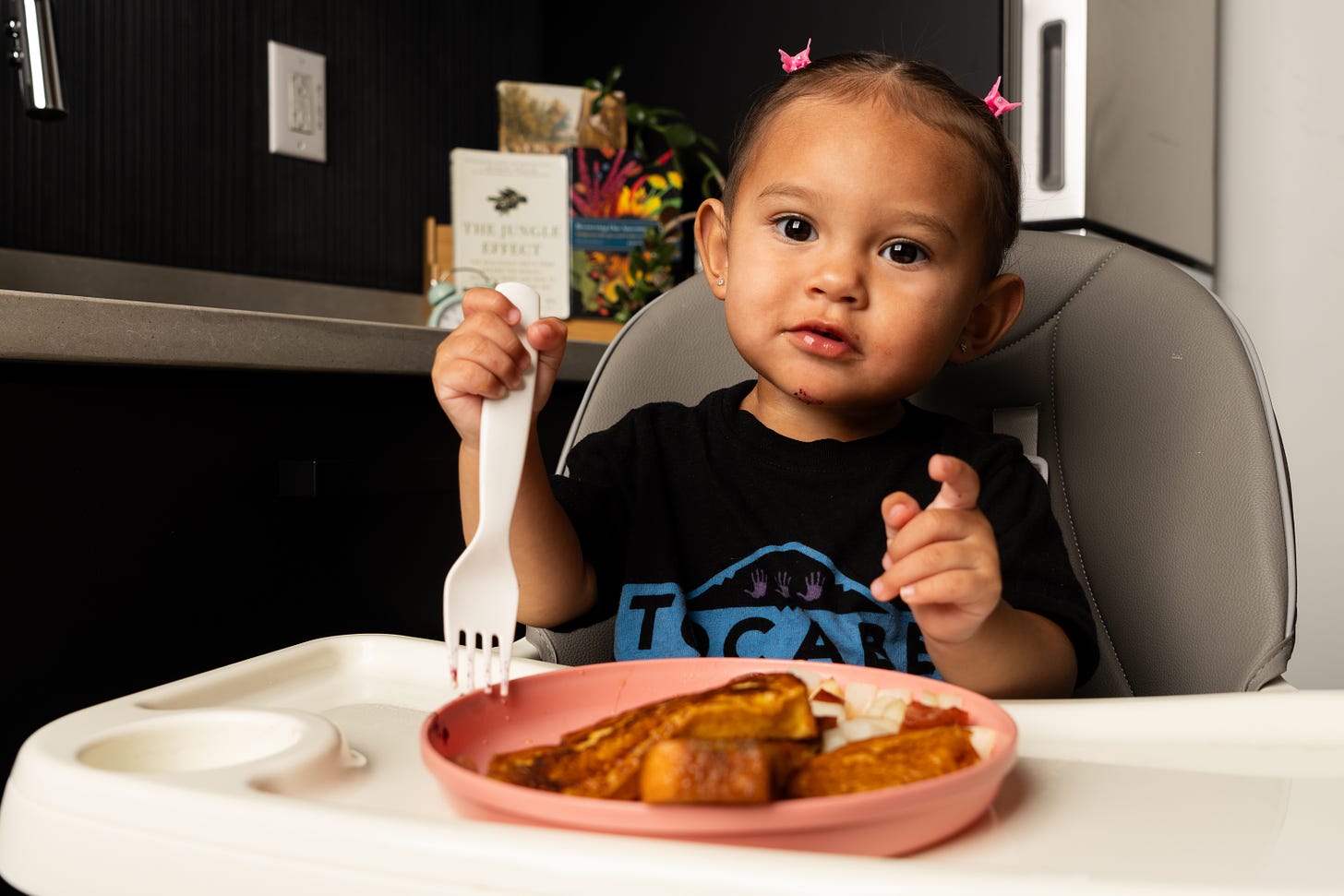 Indigenous toddler sits at booster seat