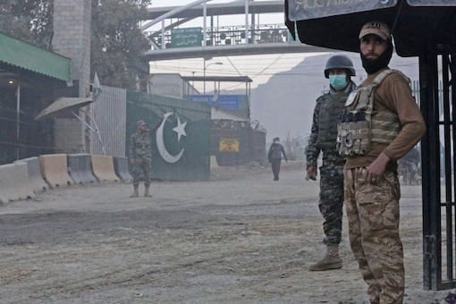 Afghan security personnel and Pakistani border policemen stand guard at the zero point Torkham border crossing between Afghanistan and Pakistan, in Nangarhar province on December 6. (Image: Shafiullah KAKAR/AFP)
