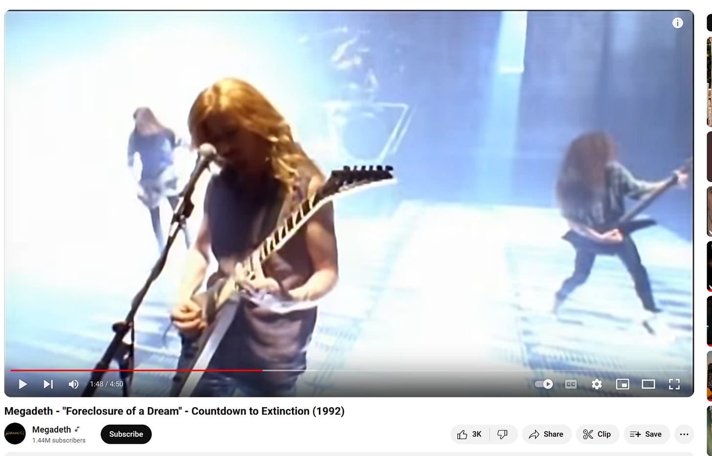 A person playing guitar and singing into a microphone

Description automatically generated