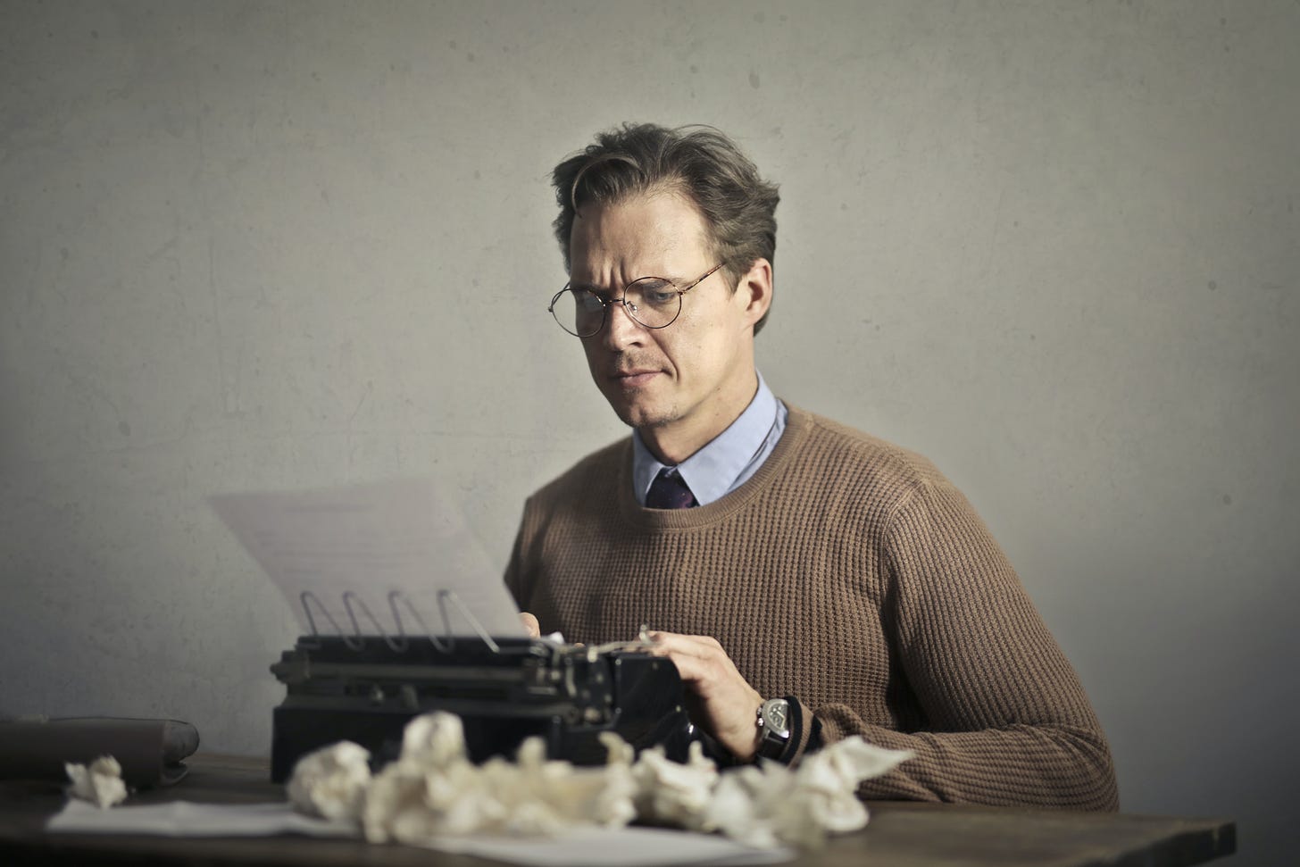 Adult frowned male writer working on typewriter at home · Free Stock Photo